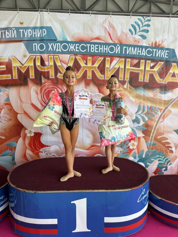 Юные гимнастки с дипломами и наградами на пьедестале турнира «Жемчужинка»